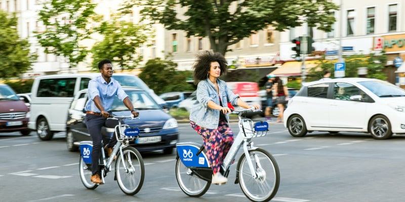 sharing-economy-tauschen-und-teilen-statt-kaufen-zwei-personen-auf-dem-fahrrad